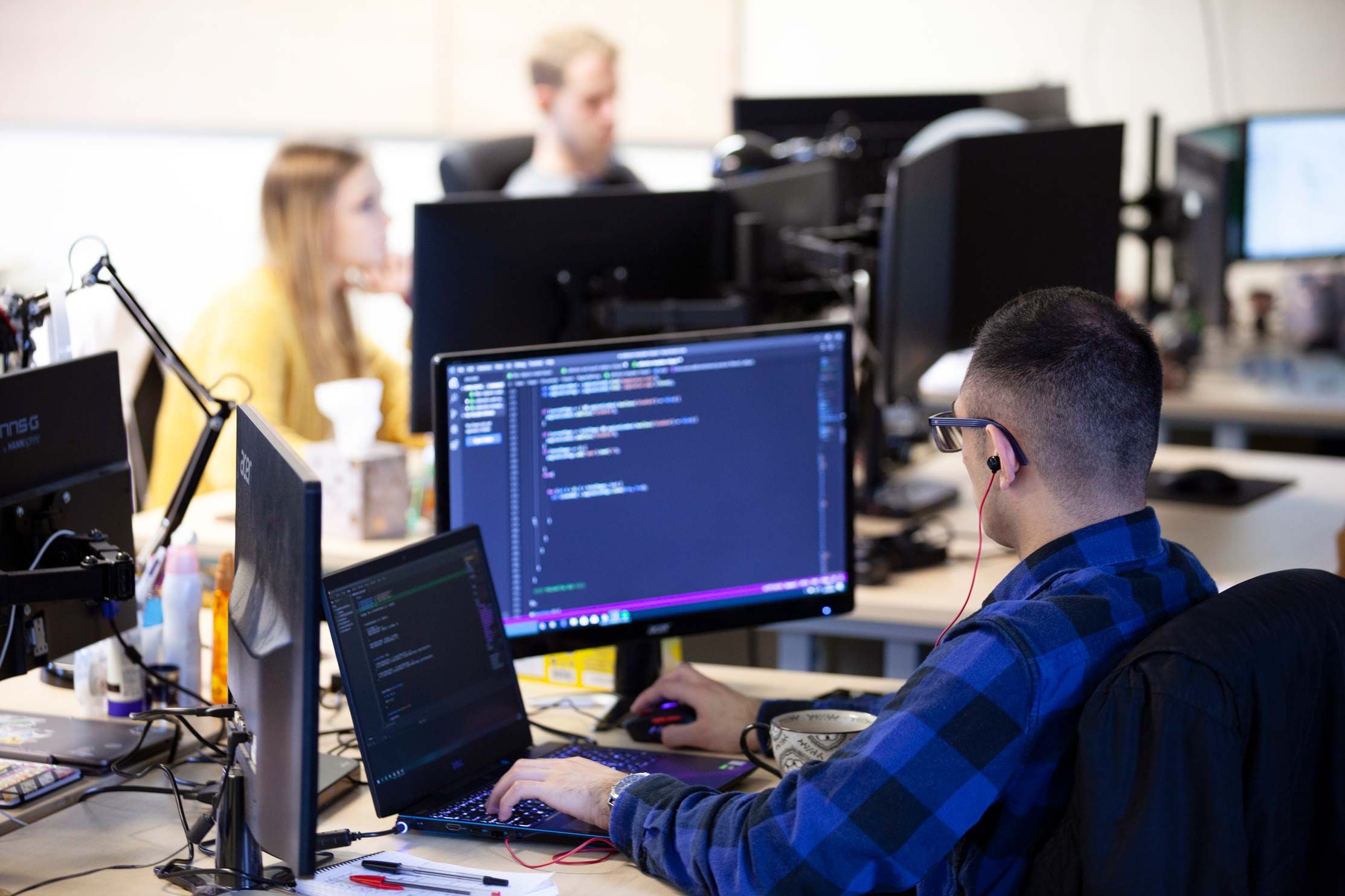 A Bournemouth Digital developer writing code at a desk in the studio
